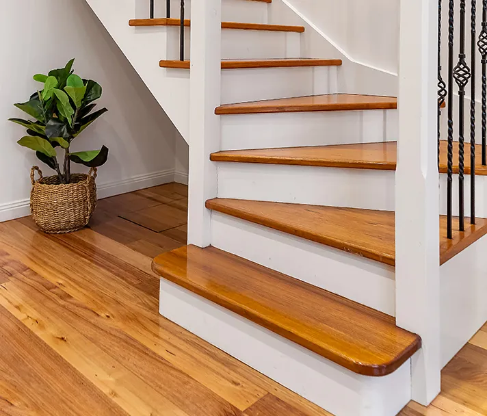 Light oak hardwood floor and matching staircase in a clean modern home
