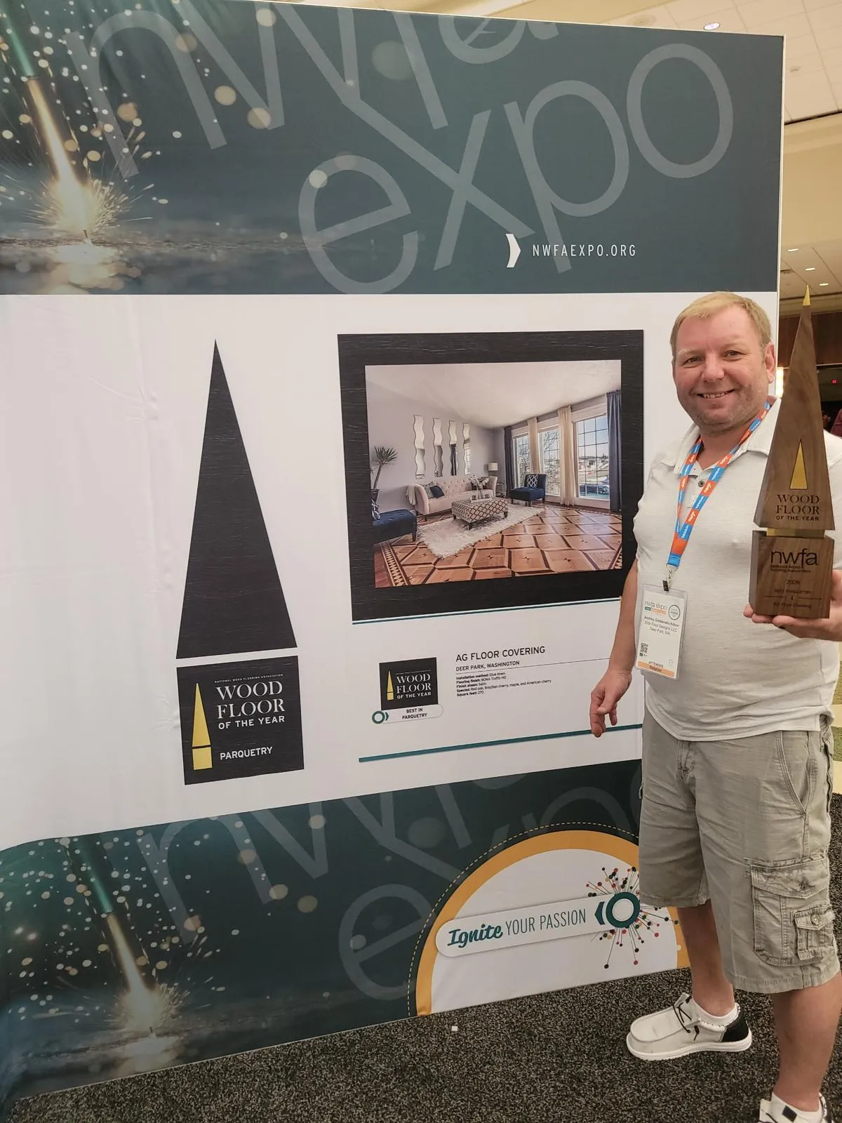 AG Floor Covering's owner holding the NWFA Wood Floor of the Year trophy at the NWFA Expo