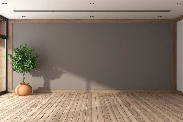 Empty room with a brown wall and freshly refinished hardwood floor