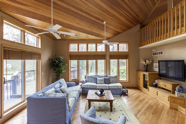 Open-plan living room with hardwood flooring and a matching wood ceiling