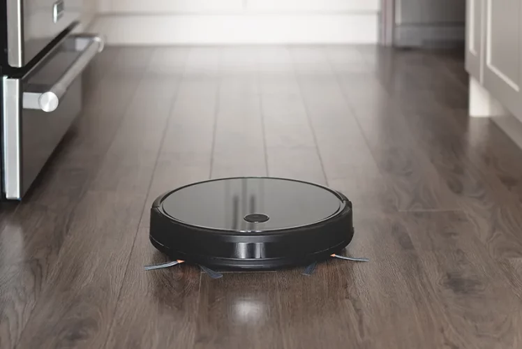 Robot vacuum cleaning a kitchen hardwood floor