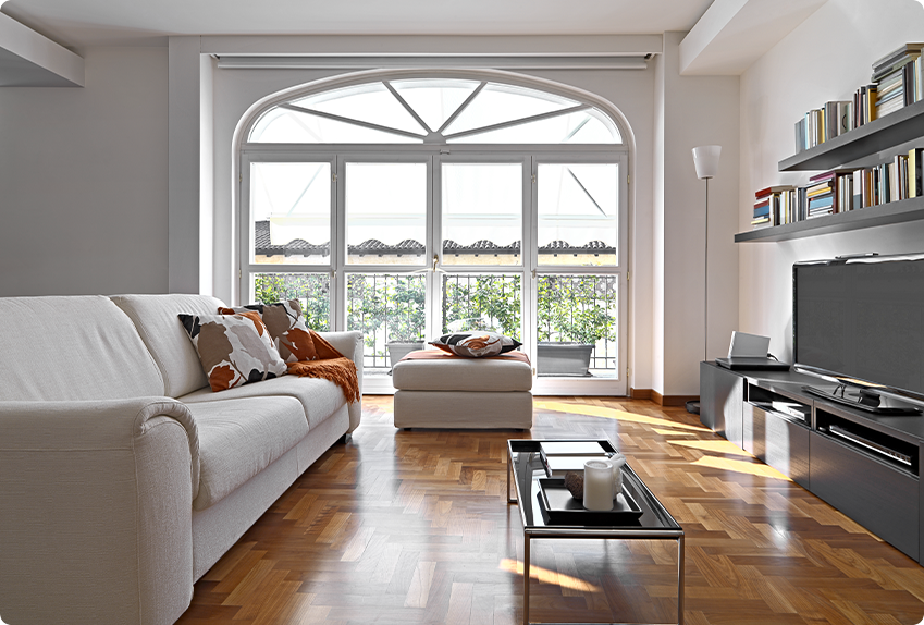 Minimalist living room with a white sofa over warm wood-look plank flooring