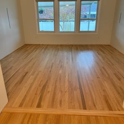 Newly installed light red oak hardwood floor in a sunlit room