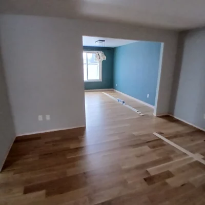 White oak hardwood floor being refinished in a room with a teal accent wall