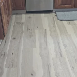 Light grey-washed laminate plank flooring installed in a kitchen by AG Floor Covering