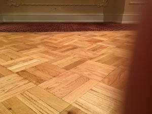 Basket-weave parquet hardwood floor running across a room with an ornate baseboard, installed by AG Floor Covering