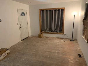 Living room with worn, unfinished 1940s hardwood floors before refinishing by AG Floor Covering
