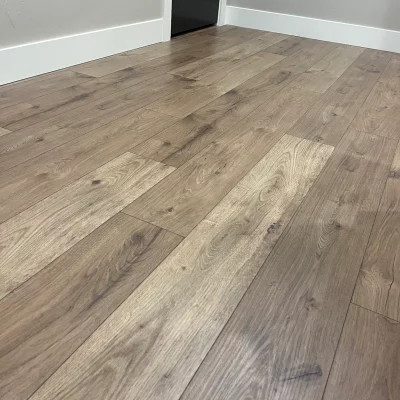 Wide grey-oak plank flooring with white baseboards