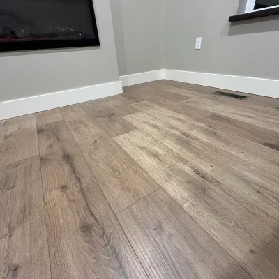 Wide grey-oak plank flooring beside a fireplace