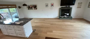 Light oak engineered hardwood flowing from the kitchen into the living room