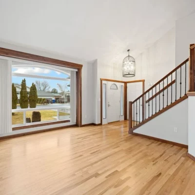 Entryway with light red oak hardwood, a picture window and a staircase