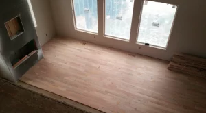 Hardwood floor mid-installation in a room before sanding and finishing