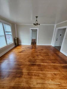 Living room with freshly refinished warm hardwood flooring in a Spokane apartment